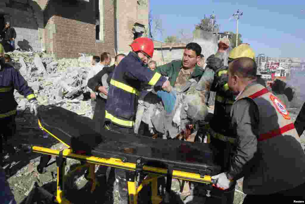 Medical personnel carry a victim to a stretcher at the site of a suicide bomb attack in Kirkuk, Iraq, February 3, 2013. 