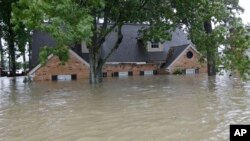 A flooded home is shown as floodwaters from Tropical Storm Harvey rise, Aug. 28, 2017, in Spring, Texas. 