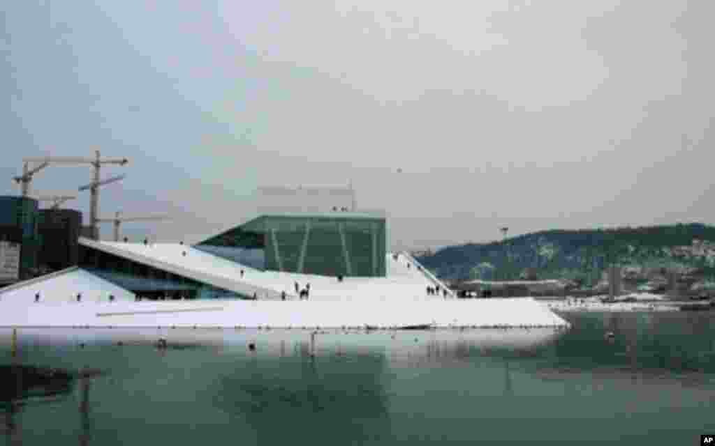 从水面浮出的奥斯陆歌剧院。这座2008年启用的建筑号称挪威数百年来规模最大的文化设施，它是挪威的国家歌剧院，挪威国家歌剧与芭蕾舞剧团以此为家。