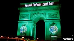 FILE - The Arc de Triomphe is illuminated in green with the words "Paris Agreement is Done," to celebrate the Paris U.N. COP21 Climate Change agreement in Paris, France, Nov. 4, 2016. 