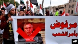 Protesters hold a poster showing Iraq's Prime Minister-designate Mohammed Tawfiq Allawi with Arabic that reads, "Rejected by order of the people," during a rally in Baghdad, Iraq, March 1, 2020.