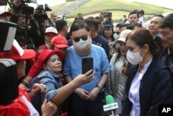 Seorang pendukung berfoto selfie dengan mantan Perdana Menteri Thailand Thaksin Shinawatra (tengah), di Rajapruek Royal Park di provinsi Chiang Mai, Thailand, Kamis, 14 Maret 2024. (AP/Anuthep Cheysakron)