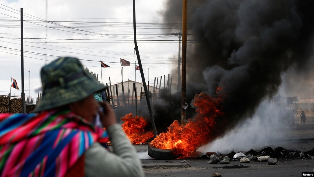 Seorang pria berdiri dekat sebuah unjuk rasa di Senkata, El Alto, Bolivia, 19 November 2019. 