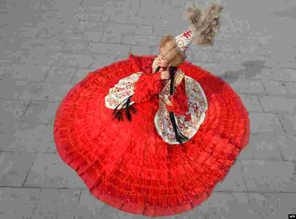 A woman wearing a traditional costume attends the celebrations marking the National Flag Day and the Day of Kyrgyz national &quot;Ak-kalpak&quot; hat at the central Ala-Too Square in Bishkek.