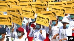 Medicals students display images of deposed Myanmar leader Aung San Suu Kyi during a street march in Mandalay, Myanmar. By midday, security forces had blocked the main road in downtown Mandalay to prevent the protesters from gathering.