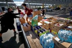 Volunteers prepare donations for delivery to those affected by COVID-19 on tribal lands June 25, 2020, in Tempe, Ariz.