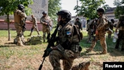 FILE - Members of a foreign volunteers unit which fights in the Ukrainian army take positions, as Russia's attack on Ukraine continues, in Sievierodonetsk, Luhansk region Ukraine June 2, 2022.