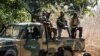 FILE - Separatists belonging to the Movement of Democratic Forces of Casamance look on during the release of seven captured Senegalese soldiers at an abandoned settlement, Baipal, in Gambia, Feb. 14, 2022. 