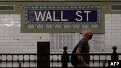 Seseorang berjalan melalui stasiun kereta bawah tanah Wall Street dekat New York Stock Exchange (NYSE) di New York, 27 Mei 2022. (Foto: AFP)