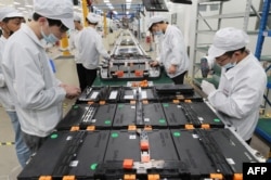 FILE - Workers at a factory for Xinwangda Electric Vehicle Battery Co. Ltd, which makes lithium batteries for electric cars and other uses, in Nanjing in China's eastern Jiangsu province, March 12, 2021. (Photo by AFP)