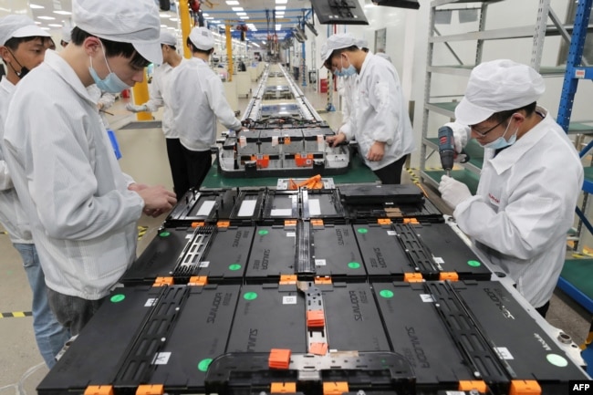 FILE - Workers at a factory for Xinwangda Electric Vehicle Battery Co. Ltd, which makes lithium batteries for electric cars and other uses, in Nanjing in China's eastern Jiangsu province, March 12, 2021. (Photo by AFP)