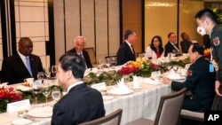 China Defense Minister Wei Fenghe, center right, talks with U.S. Secretary of Defense Lloyd Austin, left, during the 19th International Institute for Strategic Studies Shangri-la Dialogue, in Singapore, June 11, 2022.