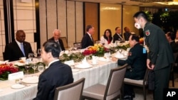 China Defense Minister Wei Fenghe, center right, talks with U.S. Secretary of Defense Lloyd Austin, left, during the 19th International Institute for Strategic Studies Shangri-la Dialogue, in Singapore, June 11, 2022.