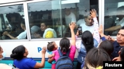 Un grupo de mujeres intentan hablar con familiares que están siendo trasladados a una prisión por policías durante el estado de emergencia, según el Ministerio de Justicia y Seguridad Pública, en San Salvador, El Salvador, el 7 de junio. 2022.