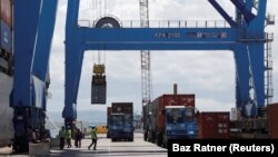 FILE: A crane loads shipping containers on a ship in the port of Mombasa, Kenya, on Oct. 23, 2019. 