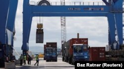 ARCHIVES - Une grue charge des conteneurs sur un navire dans le port de Mombasa, au Kenya, le 23 octobre 2019. 