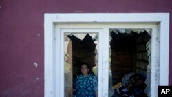 Nastasia Vladimirovna poses for a photo at her home destroyed by attacks in Mostyshche, on the outskirts Kyiv, Ukraine, June 6, 2022. Vladimirovna lived there with 18 members of her family but now is staying with neighbors.