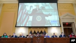 A video of former President Donald Trump speaking during a rally near the White House on Jan. 6, 2021, is shown as committee members from look on during a public hearing of the House select committee investigating the attack, June 9, 2022