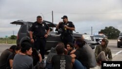 Migrantes centroamericanos que buscan asilo son detenidos por la policía después de cruzar el Río Grande hacia Eagle Pass, Texas desde México en Hondo, Texas, EEUU, el 1 de junio de 2022.