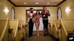 Elvis impersonator Brendan Paul, right, walks down the aisle during a wedding ceremony for Katie Salvatore, center, and Eric Wheeler at the Graceland Wedding Chapel in Las Vegas. (AP Photo/John Locher, File)