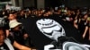 FILE - Journalists and supporters of press freedom wear black as they stage a silent march to police headquarters to denounce media treatment during a protest against extradition legislation, in Hong Kong, July 14, 2019. 