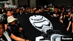 FILE - Journalists and supporters of press freedom wear black as they stage a silent march to police headquarters to denounce media treatment in Hong Kong, July 14, 2019.
