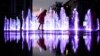 (FILE) A young girl runs in a public fountain in front of the opera house as the sun sets in Lviv, Ukraine, June 2, 2022.