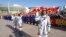 In this photo released by Xinhua News Agency, Chinese astronaut Chen Dong, right, waves as he walks ahead of fellow astronauts Liu Yang and Cai Xuzhe during a sendoff ceremony for the Shenzhou-14 crewed space mission at the Jiuquan Satellite Launch Center