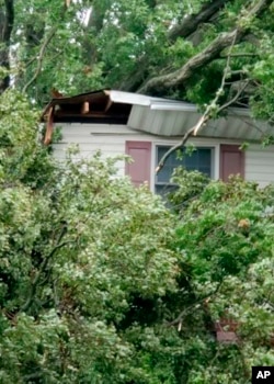 This Aug. 4, 2020, photo provided by James Burke shows damage to a Garden City, N.Y., home caused by an uprooted tree during Tropical Storm Isias. (James Burke via AP)