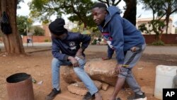 Street vendors take off their shoes to show their toes on the streets of Harare, Zimbabwe, June, 9, 2022. 