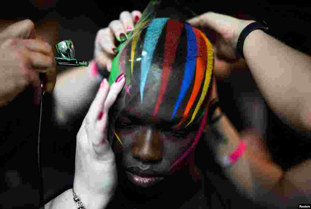 A model has makeup applied backstage ahead of the University of Westminster MA Menswear catwalk show at London Fashion Week in London, June 12, 2022. 