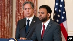 Secretary of State Antony Blinken, left, listens as Ambassador-at-Large for International Religious Freedom Rashad Hussain speaks on the release of the 2021 International Religious Freedom Report, at the State Department, June 2, 2022, in Washington.