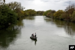 FILE - People fish in the Sacramento-San Joaquin River Delta's Elk Slough near Courtland, Calif., Tuesday, March 24, 2020. A proposal in the California state Senate aims to keep more water in California's rivers and streams to benefit endangered species of fish. (AP Photo/Rich Pedroncelli, File)