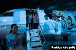 Putri Diego Maradona, Dalma, dan Yanina, di depan pesawat yang didedikasikan untuk mendiang legenda sepak bola di Buenos Aires, Argentina, Rabu, 25 Mei 2022. (Foto: AP )