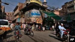 FILE - People move through Qissa Khwani market in downtown Peshawar, the capital of Pakistan's Khyber Pakhtunkhwa province, Oct. 8, 2021. Due to rising energy costs, provincial authorities have designated Fridays as work-from-home days.