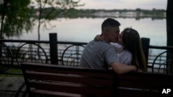 A couple kiss at Natalka Park in Kyiv, Ukraine, June 7, 2022.