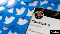 FILE - Elon Musk's Twitter profile is seen on a smartphone placed on printed Twitter logos in this picture illustration taken April 28, 2022. 