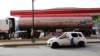 Un hombre tira de su auto junto a un camión de gasolina en una gasolinera en Caracas, Venezuela, el 14 de noviembre de 2020.