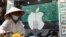 Một người bán rong đi ngang qua một cửa hàng bán sản phẩm của Apple ở Hà Nội. Theo Bloomberg và Business Insider, các công ty của Trung Quốc đang tranh giành công nhân của nhà sản xuất lớn nhất cho Apple ở Việt Nam.