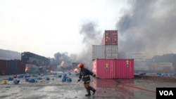 A fireman was seen trying to douse the fire on Sunday noon. The fire couldn’t be doused even after 17 hours. (Minhaz Uddin/VOA)