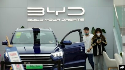 People visit a Chinese automaker BYD store on Wednesday, March 16, 2022, in Beijing.