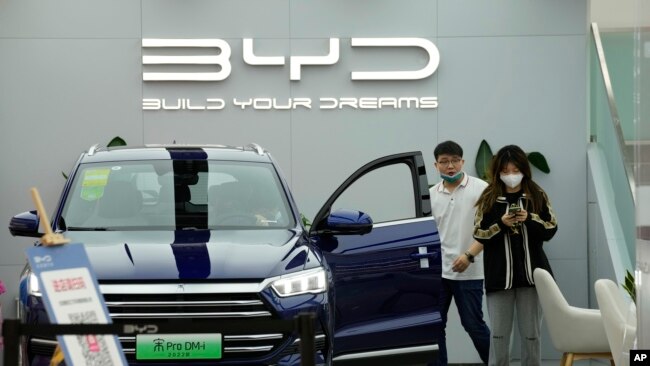 People visit a Chinese automaker BYD store on Wednesday, March 16, 2022, in Beijing.