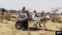 FILE: People use a donkey-pulled cart to transport items left behind by the United Nations - African Union Mission in Darfur (UNAMID). Taken June 30, 2021