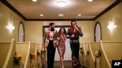 FILE - In this Feb. 14, 2019 photo, Elvis impersonator Brendan Paul walks down the aisle during a wedding ceremony for Katie Salvatore, center, and Eric Wheeler at the Graceland Wedding Chapel in Las Vegas.