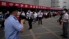 中国高考第一天，北京一处考场外警察和学校教师使用扩音器要求在外等候的考生家长遵守秩序。（2022月6月7日）