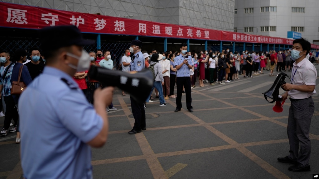 中国高考第一天，北京一处考场外警察和学校教师使用扩音器要求在外等候的考生父母与亲属守秩序。（2022月6月7日）(photo:VOA)