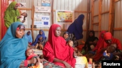 FILE - Internally displaced Somali women carry their children as they wait for malnutrition screening at the Dollow hospital in Dollow, Gedo region, Somalia, May 24, 2022.