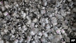 FILE - Discarded COVID-19 vaccine vials lie in a box at a vaccination site in Ebersberg, near Munich, Germany, May 15, 2021.