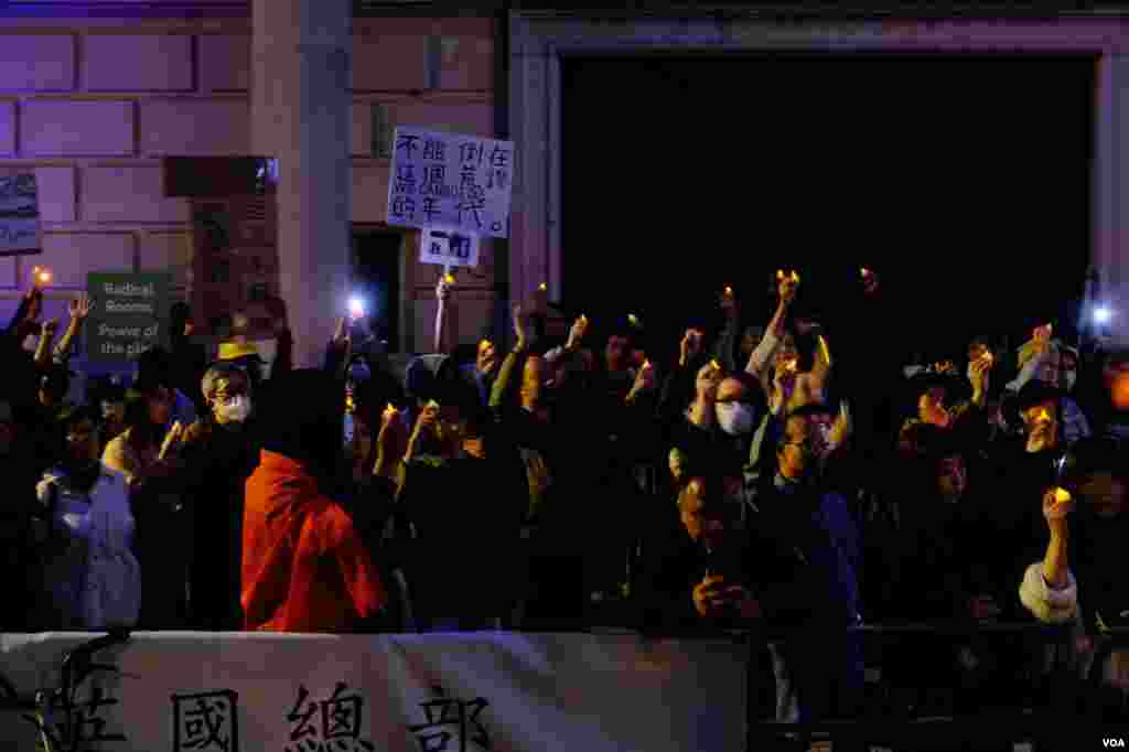 示威者在中國大使館對面馬路的英國皇家建築師學會(Royal Institute of British Architects)大樓外的行人道上舉行燭光守夜。（美國之音鄭樂捷）