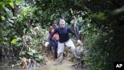 FILE - British journalist Dom Phillips (front) and a Yanomami Indigenous man walk in Maloca Papiu village, Roraima state, Brazil, November 2019. 